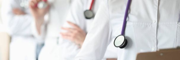 Group of doctors with stethoscope around their neck stands in clinic closeup - Photo, image