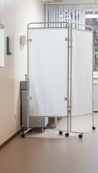 Intérieur d'un cabinet de médecin lumineux avec un écran pliant, cadre vertical. - Photo, image