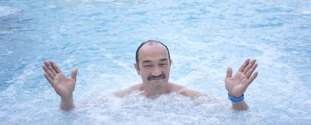 maduro ásia homem no exterior termal piscina com hidromassagem. - Foto, Imagem