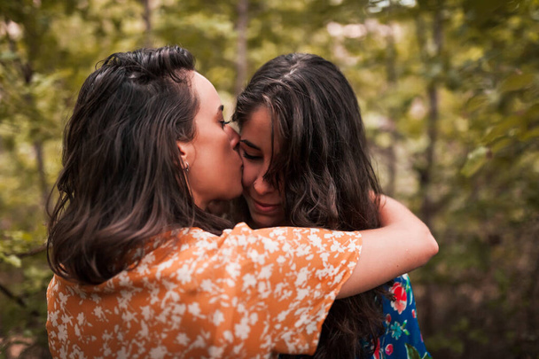 Due giovani lesbiche che si baciano e si accarezzano nel bosco - Foto, immagini