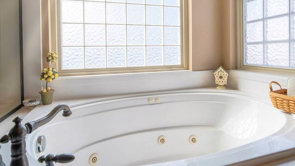Пано Буэно в круглой ванне внутри ванной с цветочными шторами на окнах - Фото, изображение