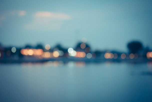 Belles lumières de ville floues avec effet bokeh réfléchi sur fond d'eau
 - Photo, image