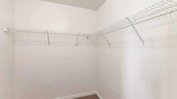 Pano üres tároló helyiség falra szerelt fehér fém polcokkal és kampókkal - Fotó, kép