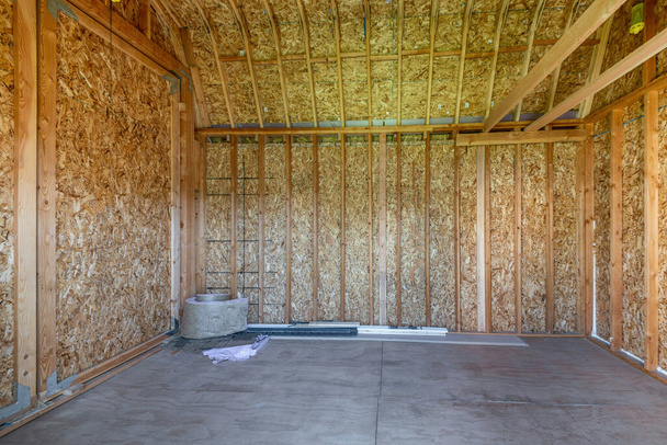Wnętrze pustej szopy z drewnianymi ramami i podłogą betonową - Zdjęcie, obraz