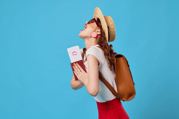 kobieta w kapeluszu z paszportem i bilety lotnicze podróży zabawy marzenia niebieskie tło - Zdjęcie, obraz
