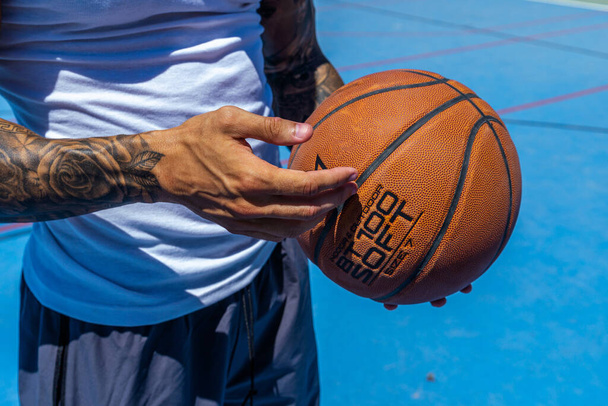 A view of a sporty Caucasian male's hands holding a basketball ba - Фото, изображение