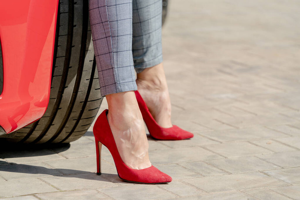 Girl in red shoes and a red car on a summer sunny day.  - Foto, imagen