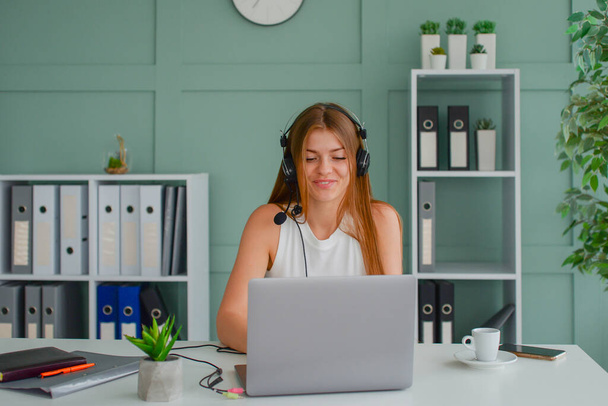 Жінка-підприємець. Веселий бізнесмен розмовляє по телефону, працює на ноутбуці в сучасному офісі. Порожній простір
 - Фото, зображення