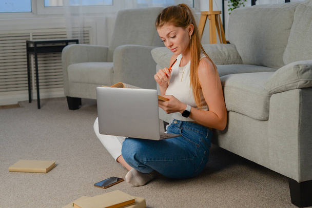 Προσεκτική και κουρασμένη συγκεντρωμένη νεαρή γυναίκα που κρατά λογαριασμούς χαρτιού εισάγει πληροφορίες χρέωσης σε εφαρμογή υπολογιστή, πληρώνει λογαριασμούς κοινής ωφέλειας σε απευθείας σύνδεση χρησιμοποιώντας μόνο λογισμικό laptop στο σπίτι. - Φωτογραφία, εικόνα