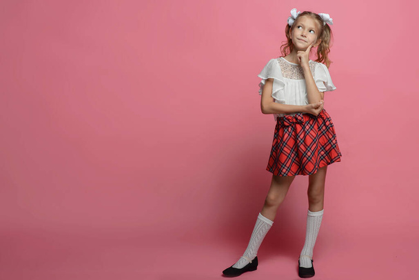 portrait of a schoolgirl girl with different emotions on a pink background - Photo, image