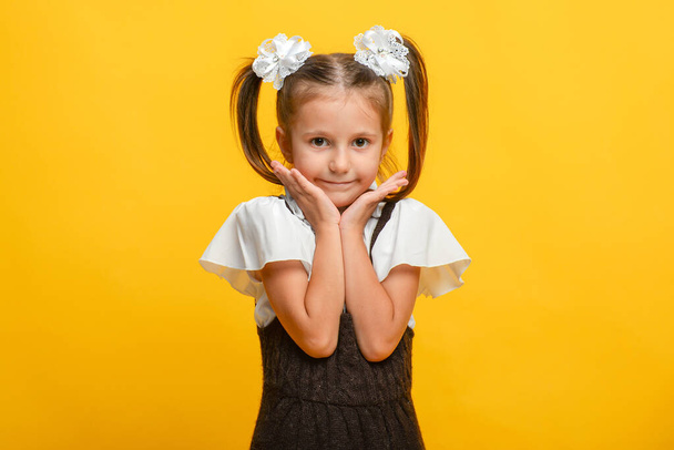 portrait of a schoolgirl girl with different emotions on a yellow background - Фото, зображення