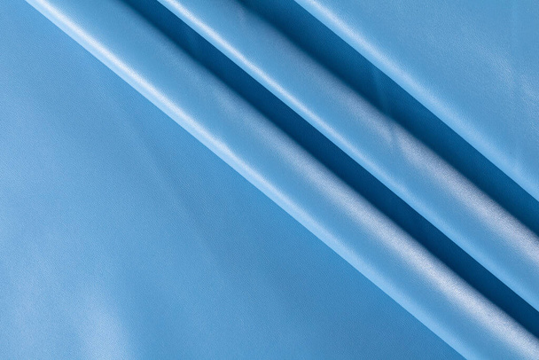 surface with folds of artificial leather for sewing clothes in blue sky colore, background - Foto, Imagem
