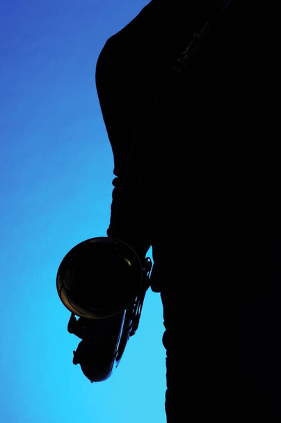 silhouette of a man with a knife on a blue background - Фото, зображення