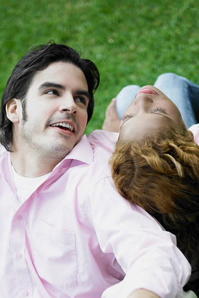 portrait of a young couple lying on a bench in the park - Foto, Imagem