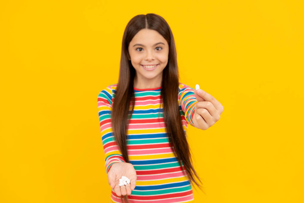 happy teen girl showing natural food additives or vitamin pills, vitamin - Foto, afbeelding