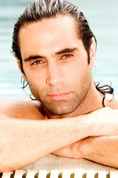 Retrato de un hombre adulto medio descansando sus brazos en el borde de una piscina
 - Foto, imagen