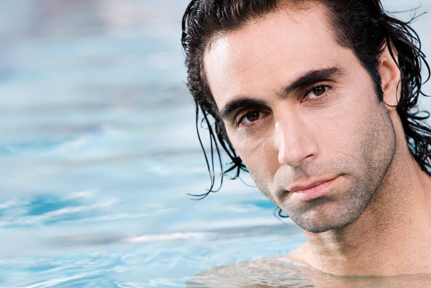 Portrait of a mid adult man swimming in a swimming pool - Foto, afbeelding