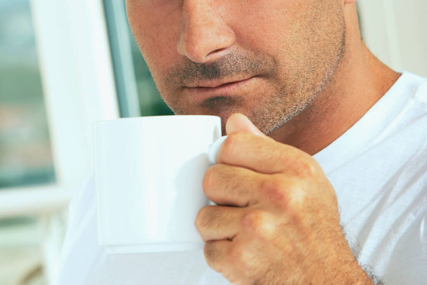 Close-up of a mid adult man holding a cup of coffee - Zdjęcie, obraz