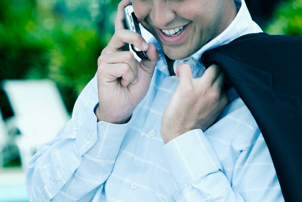 Close-up of a businessman talking on a mobile phone and smiling - Foto, immagini
