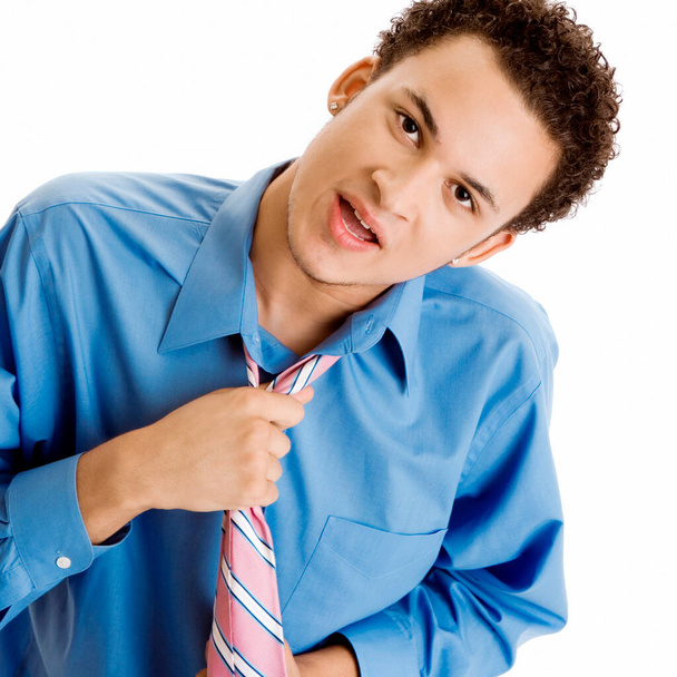 Portrait of a young man pulling his tie - Foto, Bild
