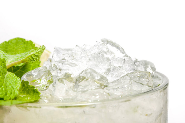Αλκοολούχο κοκτέιλ σε ποτήρι σε λευκό φόντο. Απομονωμένοι. Cocktail διακόσμηση: σιρόπι, πάγος, μέντα - Φωτογραφία, εικόνα