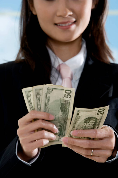 Nahaufnahme einer Geschäftsfrau, die amerikanische Papierwährung zählt - Foto, Bild