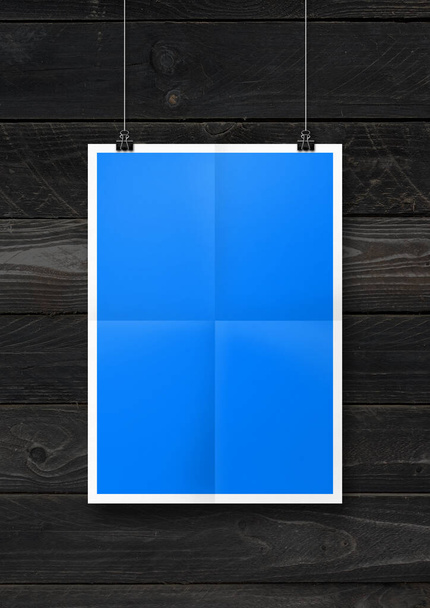 Blue folded poster hanging on a black wooden wall with clips. Blank mockup template - Fotografie, Obrázek