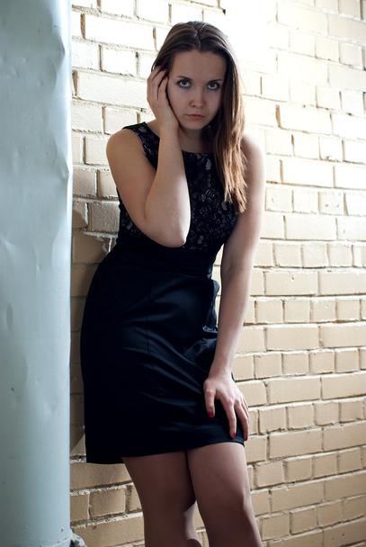 Portrait of young girl near the brick wall - Fotó, kép