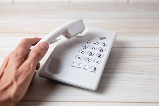 hand holding a home phone receiver - Foto, afbeelding