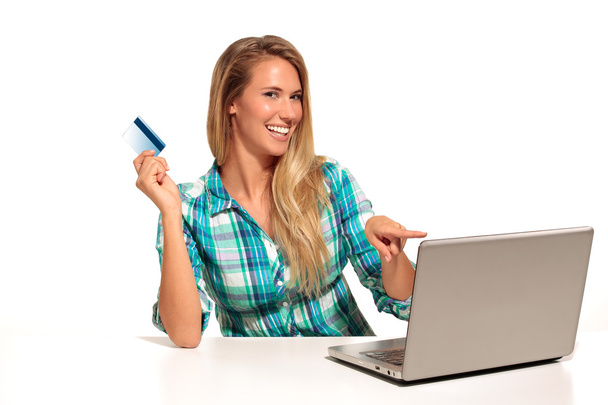 Jeune femme assise au bureau faisant du shopping en ligne
 - Photo, image