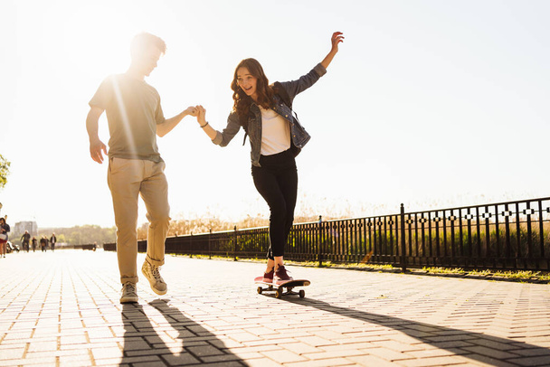 Young Couple practicing skateboarding outdoors - Foto, imagen