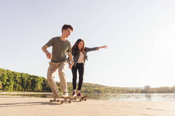 Νεαρό ζευγάρι εξάσκηση skateboarding έξω - Φωτογραφία, εικόνα