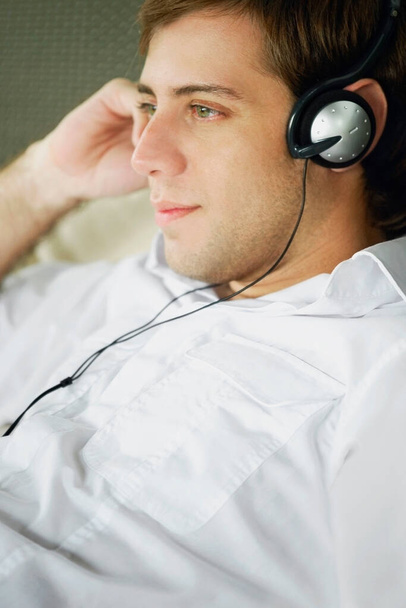young man listening to music on headphones - Foto, afbeelding