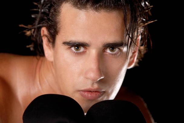 Portrait of a young man wearing boxing gloves - Foto, afbeelding