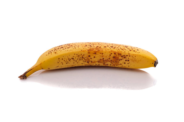 Ripe yellow banana with brown spots white isolated - Fotó, kép
