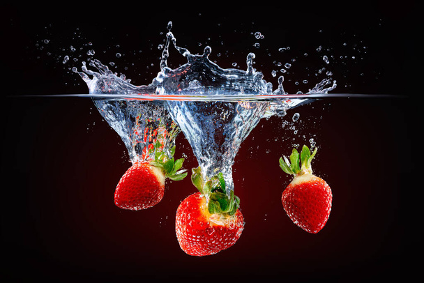 fresh strawberries falling into splashing water - Zdjęcie, obraz