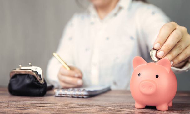 Female business woman doing administration, counting and saving money with pink piggy bank, business, savings,tax,financial concept background office table - Fotografie, Obrázek