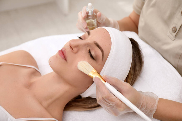 Young woman during face peeling procedure in salon - Photo, Image