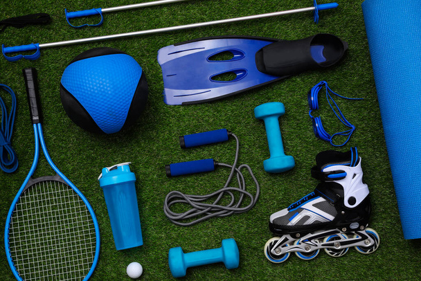 Different sport equipment on green grass, flat lay - Φωτογραφία, εικόνα