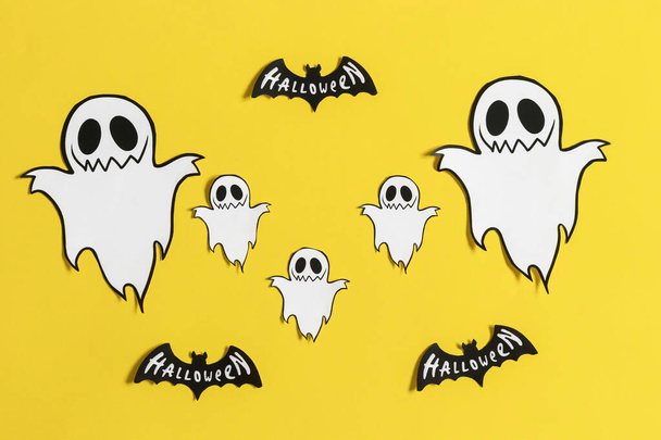 Fantasmi e pipistrelli su uno sfondo giallo e blu. Festa di Halloween - Foto, immagini