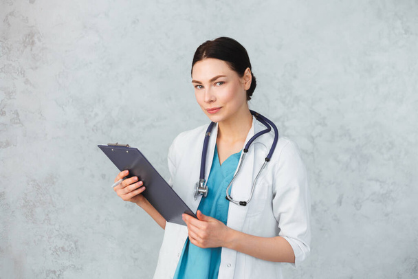 Young female doctor with stethoscope and folder. caucasian brunette. - Photo, Image