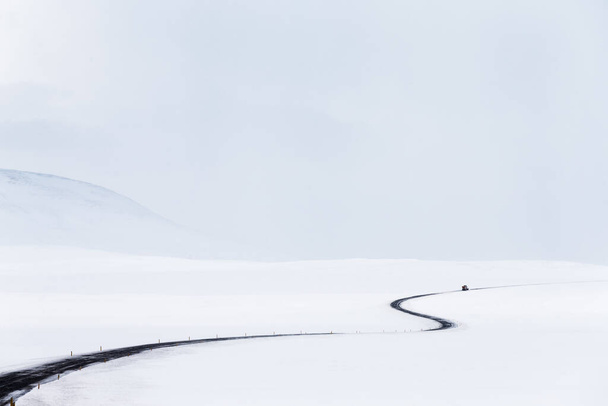 Amazing Winter Landscape. Empty Road among Fields covered with Snow. Natural Grey White Background. Stormy Weather of Iceland. - Photo, image