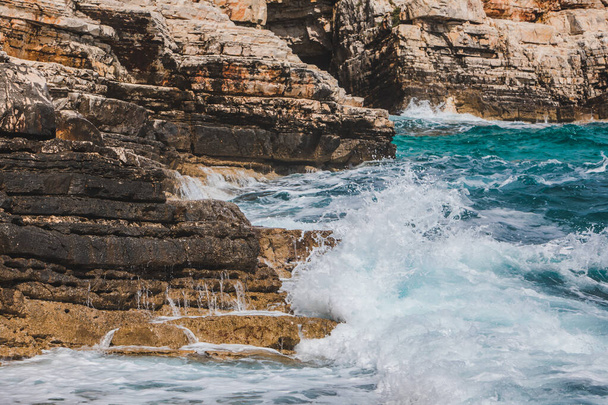 vista de olas rocosas junto al mar con espuma blanca. espacio de copia - Foto, Imagen