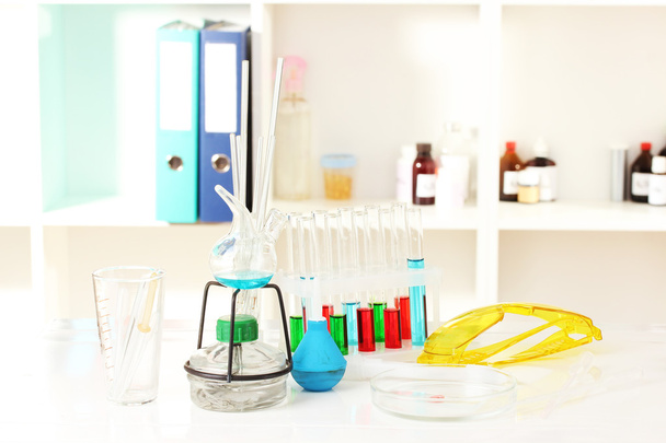 Different laboratory glassware with color liquid on laboratory background - Foto, Imagem