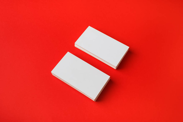 Two blank business cards on red paper background. Branding mockup. - Foto, imagen