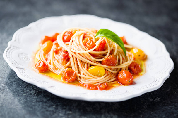 close up of plate of rustic italian cherry tomato spaghetti pasta blur defocused - Fotó, kép