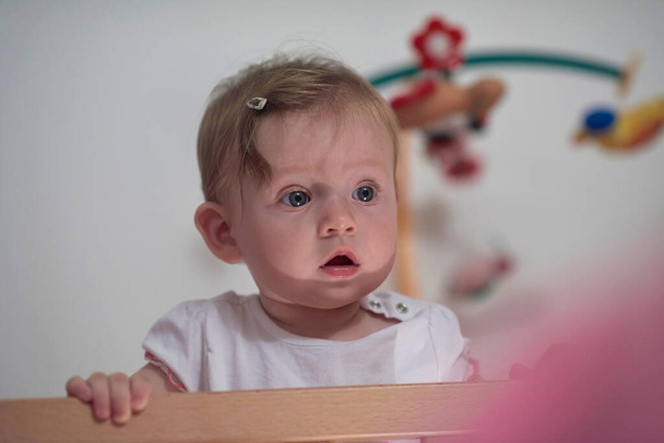 cute little one year old baby playing with toys in bed while making first steps and learnig to walk - Foto, Imagem