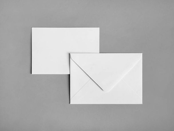 Twee blanco papieren enveloppen op grijze papieren achtergrond. Voor en achter. Vlakke plaat. - Foto, afbeelding