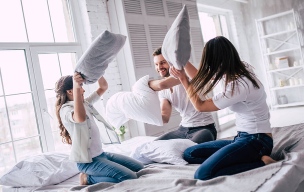 The happy family fighting with pillows - Фото, зображення