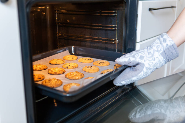 улыбающаяся женщина печет печенье на домашней кухне копировальное место - Фото, изображение
